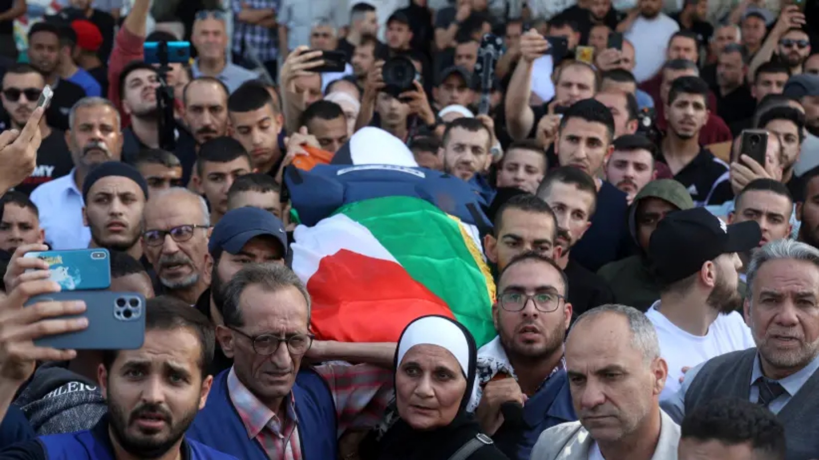 مشيعون يحملون جثة الصحافية الفلسطينية في قناة الجزيرة شيرين أبو عاقلة، التي قُتلت خلال اشتباكات بين مسلحين فلسطينيين وقوات الجيش الإسرائيلي في جنين، 11 مايو 2022
