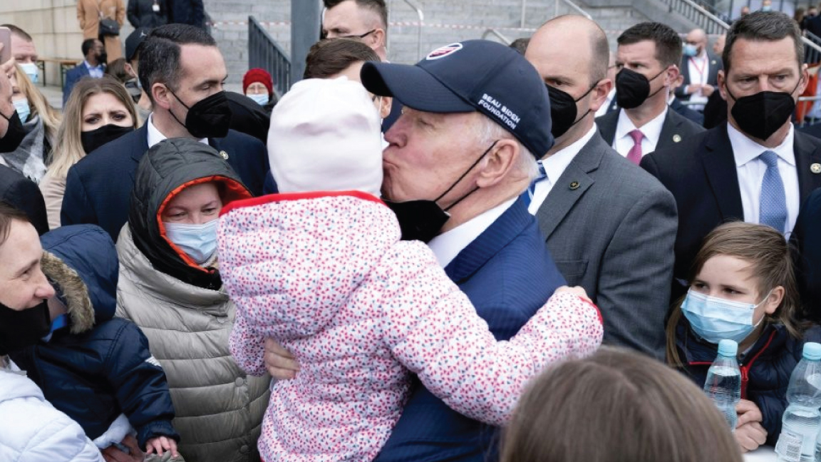 الرئيس الأميركي جو بايدن يقبل طفلاً أثناء لقاء اللاجئين الأوكرانيين في وارسو في 26 مارس 2022