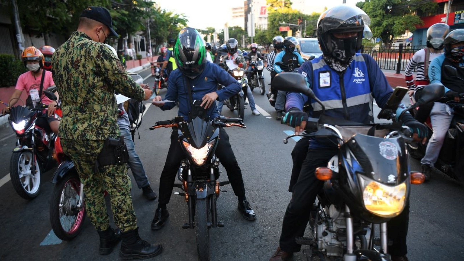 شرطي يدقّق في أوراق سائقي سيارات عند نقطة تفتيش في مانيلا 8 ايار 2022