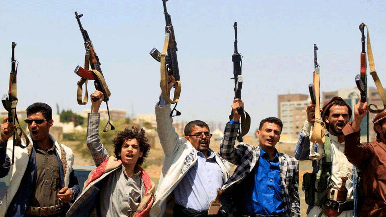 مقاتلون يمنيون موالون للمتمردين الحوثيين المدعومين من إيران يرفعون أسلحتهم أثناء تجمعٍ حاشد في صنعاء.