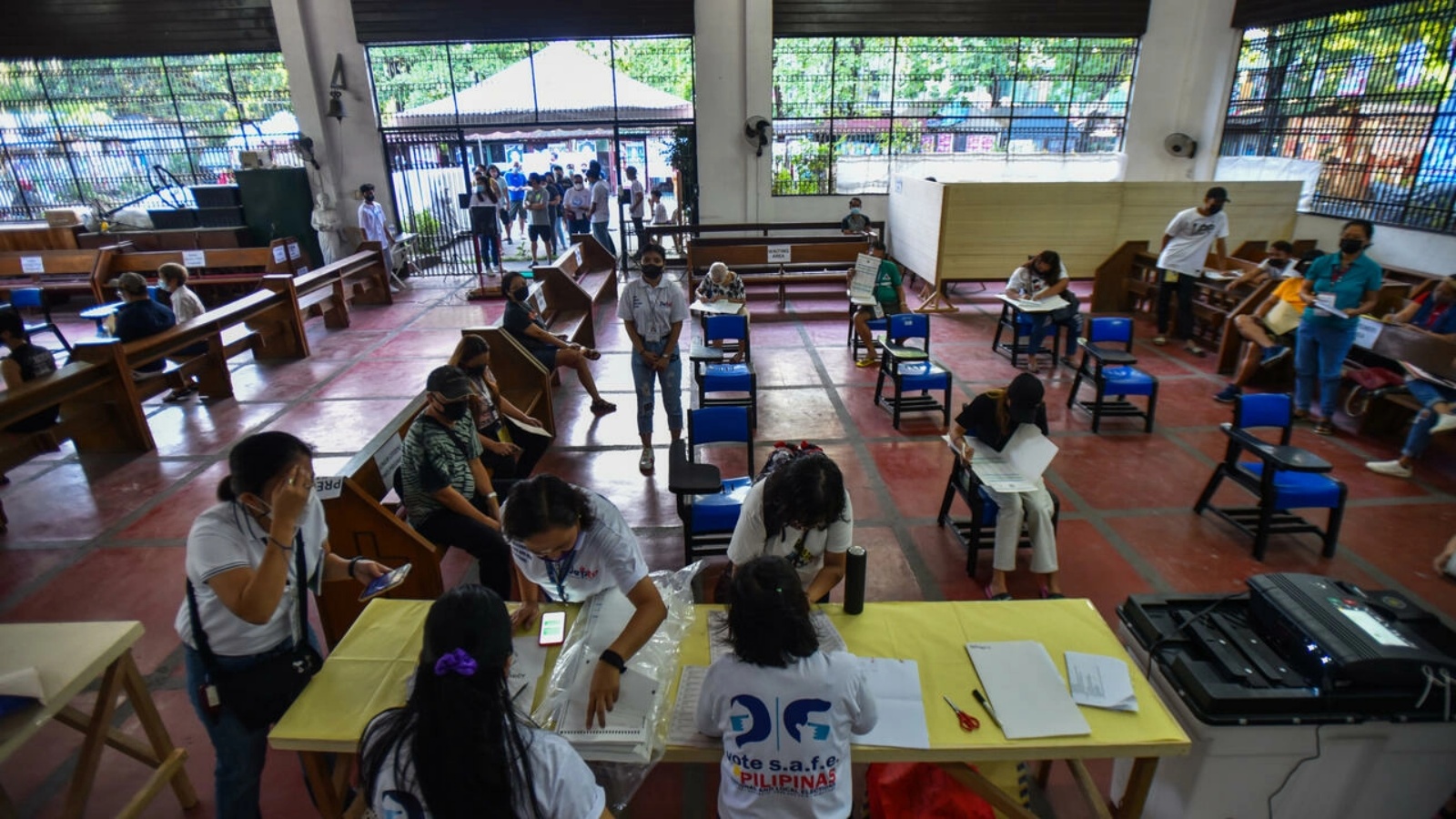 فيليبينيون يدلون بأصواتهم داخل كنيسة أقيم فيها مركز اقتراع في الانتخابات الرئاسية في مدينة كويزون بضواحي مانيلا في 9 مايو 2022