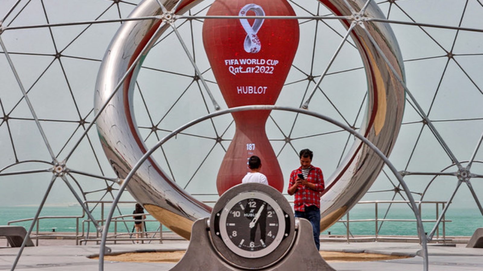 أشخاص عند الساعة التي تعد الأيام التي تبدأ فيها بطولة كأس العالم لكرة القدم قطر 2022 في العاصمة القطرية الدوحة في 17 مايو 2022