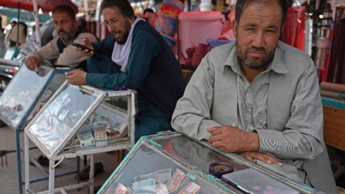 صرافون أفغان ينتظرون العملاء على طول شارع بالقرب من سوق صرافة ساراي شاهزادا في كابول