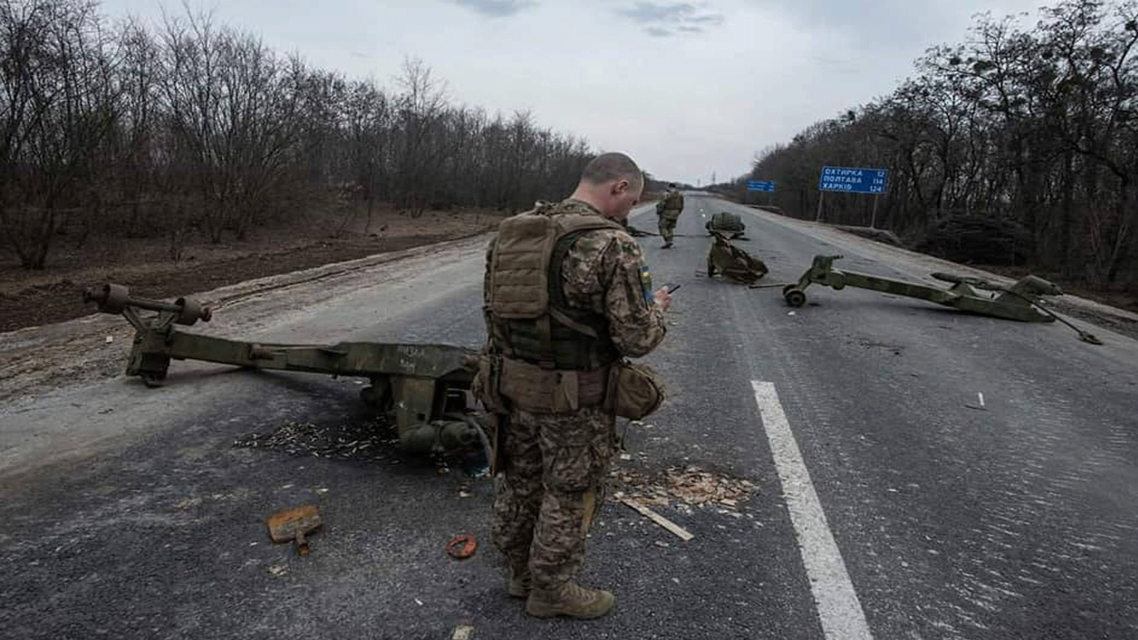 عسكري أوكراني قرب معدات عسكرية مدمرة بعد معركة في بلدة تروستيانتس