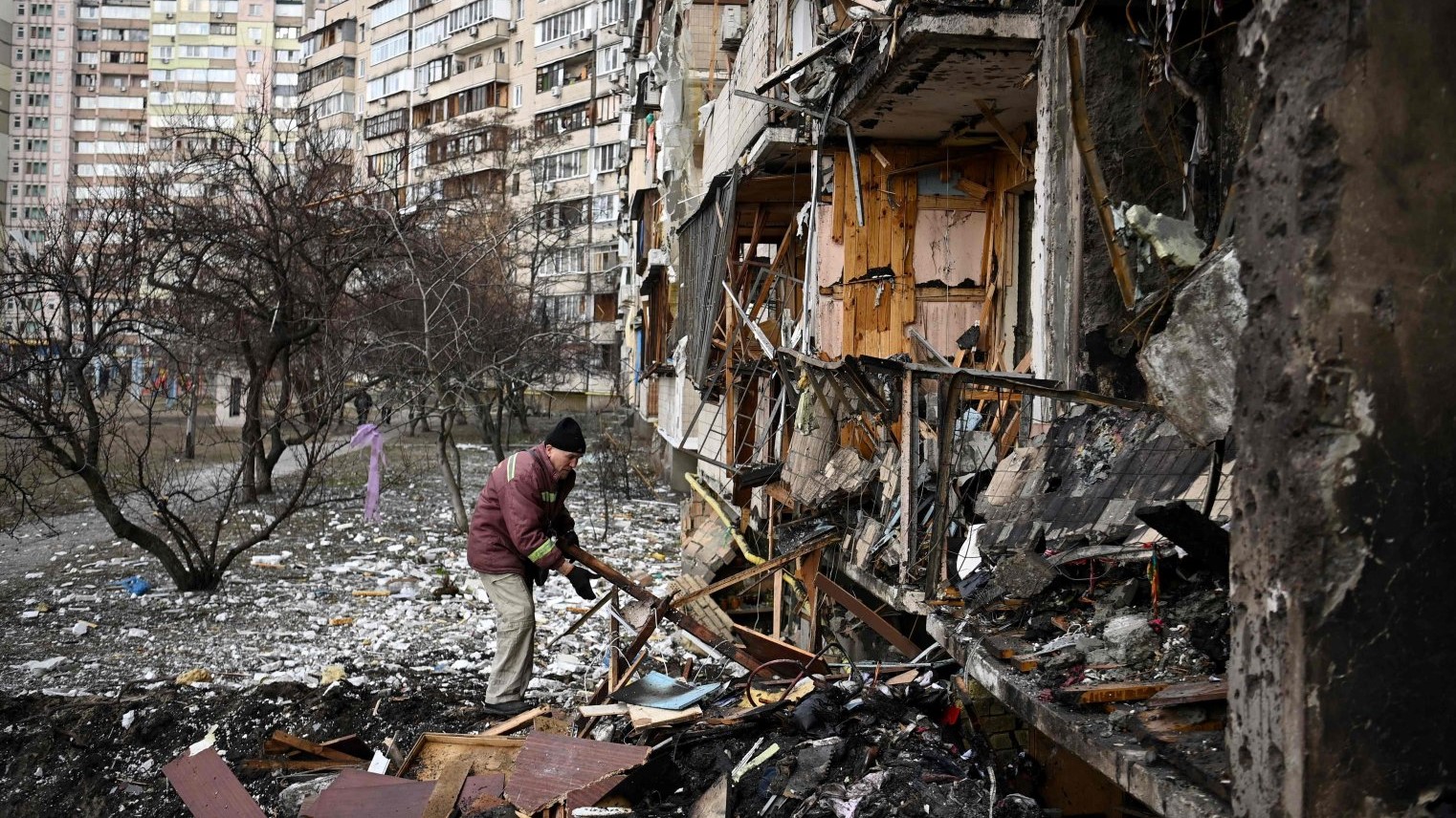 رجل يزيل الركام في مبنى سكني متضرر في شارع كوشيتسا، إحدى ضواحي العاصمة الأوكرانية كييف ، حيث قيل إن قذيفة عسكرية سقطت في 25 فبراير 2022