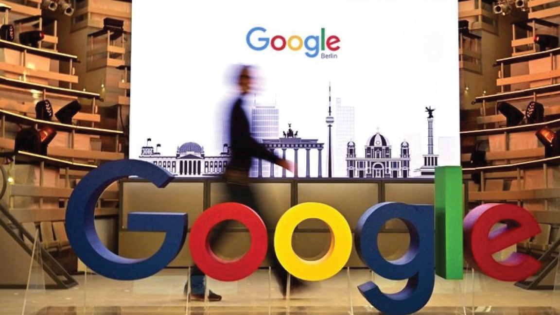 أحد الفنيين يمر بشعار شركة غوغل العملاقة للبحث على الإنترنت في الولايات المتحدة خلال يوم افتتاح مكتب جديد لشركة غوغل في برلين