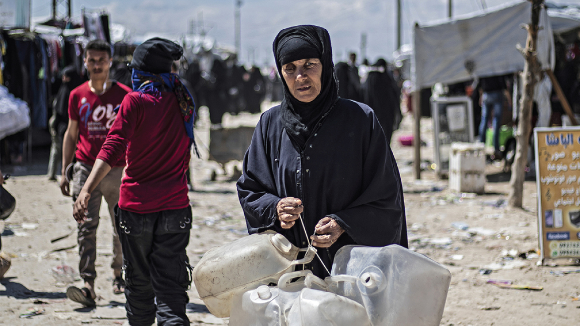 سورية نازحة من دير الزور تمشي في مخيم الهول بمحافظة الحسكة