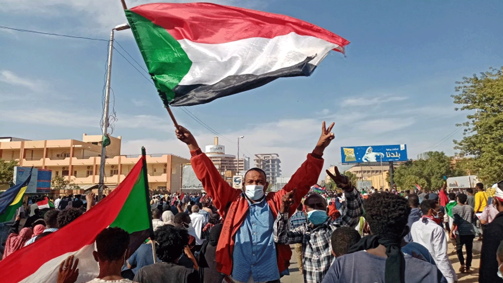 متظاهر سوداني يلوّح بالعلم الوطني خلال مسيرة مناهضة للانقلاب في العاصمة الخرطوم