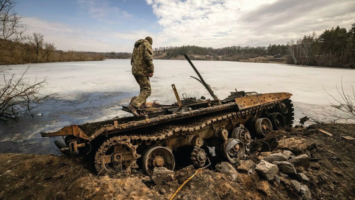 جندي أوكراني يقف بالقرب من دبابة روسية مدمرة في شمال شرق مدينة تروستيانتس، في 29 مارس 2022