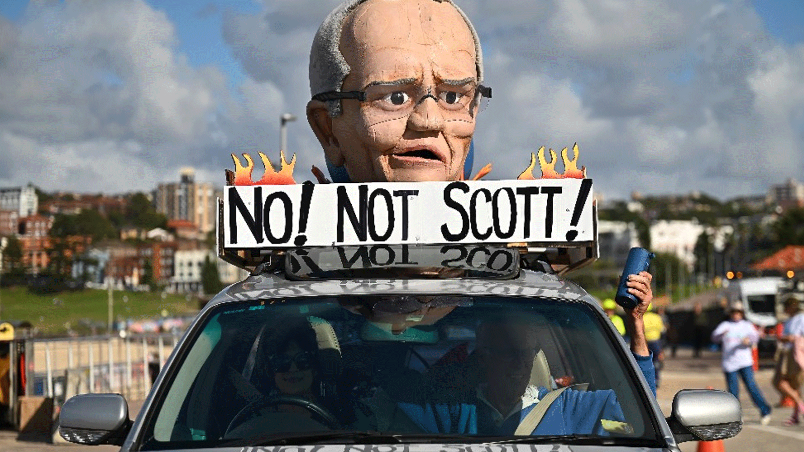 أستراليون يرفعون شعار المعارضة لسكوت موريسون رئيس الوزر اء الاسترالي الذي أقر بخسارته للانتخابات