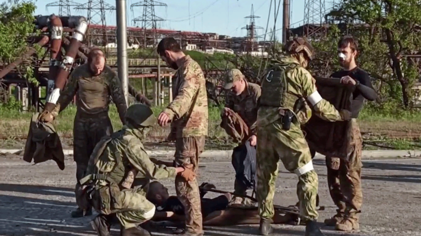 لقطة من مقطع فيديو نشرته وزارة الدفاع الروسية في 17 مايو\ أيار لجنود أوكرانيين أثناء تفتيشهم من قبل أفراد عسكريين انفصاليين بعد مغادرة مصنع آزوفستال للصلب المحاصر في مدينة ماريوبول الساحلية.