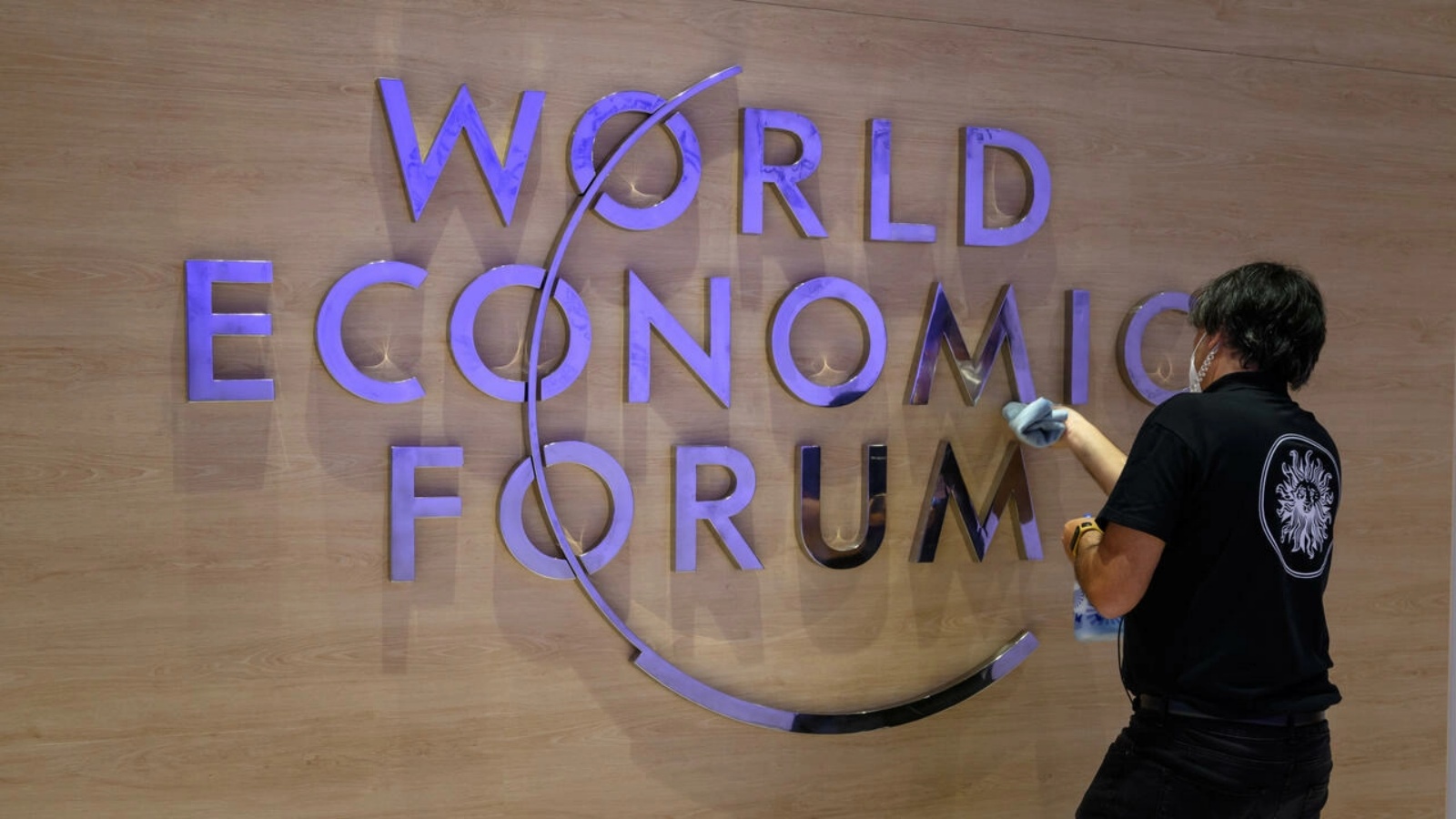 موظفة تنظف شعار المنتدى الاقتصادي العالمي في مركز المؤتمرات في دافوس بسويسرا في 22 مايو 2022
