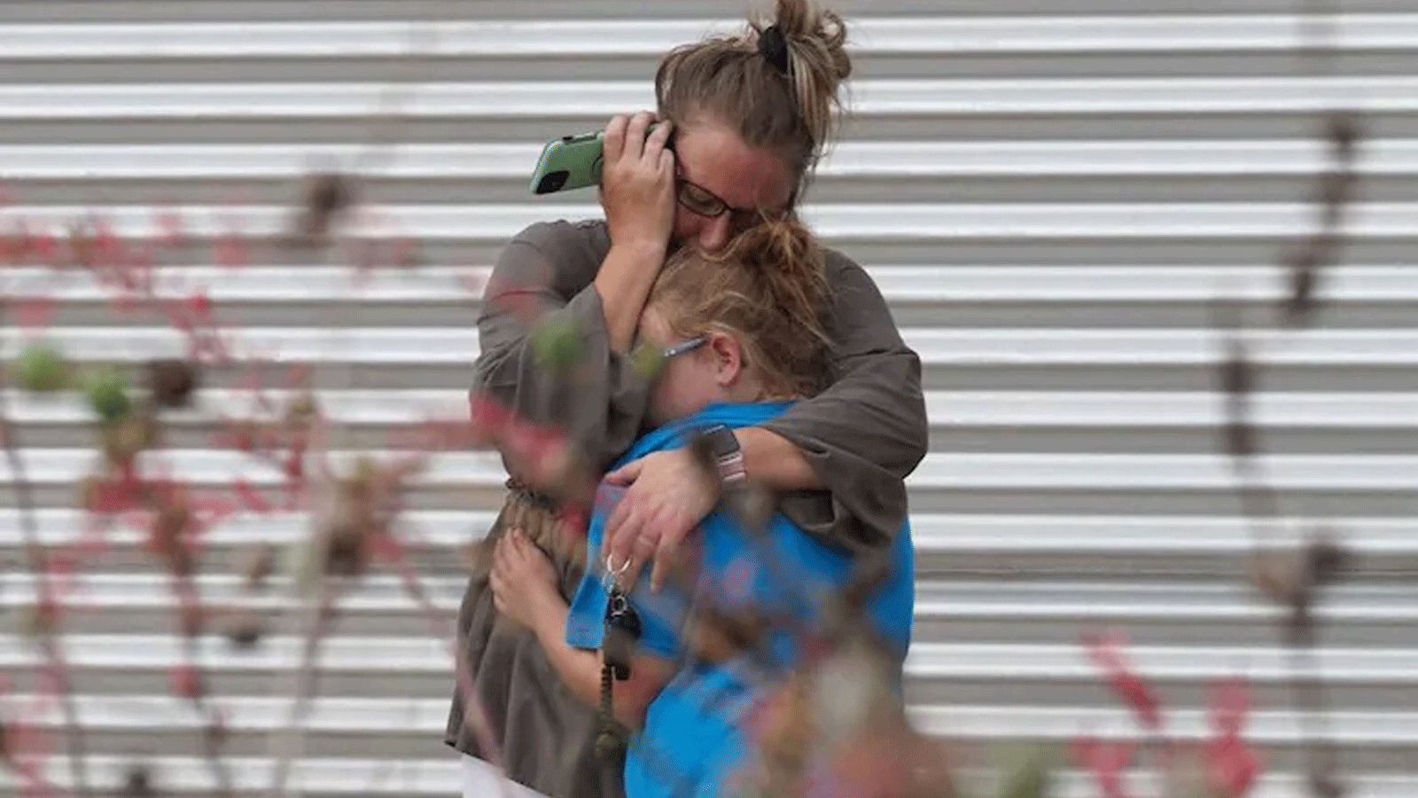 امرأة تبكي وتحتضن فتاة صغيرة خارج مركز ويلي دي ليون سيفيك، حيث سيتم تقديم الدعم النفسي في أعقاب إطلاق النار على المدرسة في أوفالدي، تكساس، يوم الثلاثاء.
