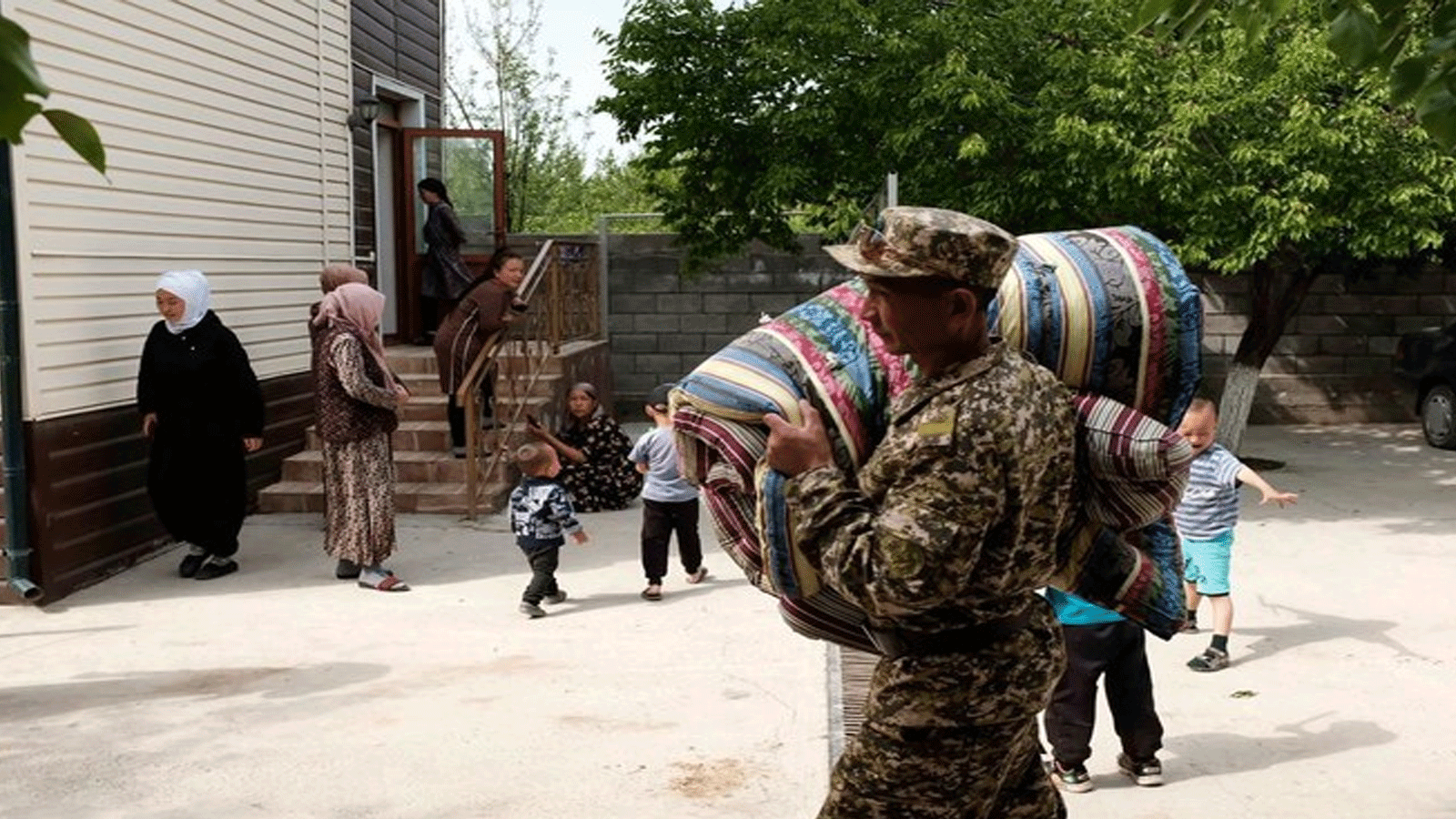 جندي قرغيزي يحمل مراتب للمواطنين، الذين تم إجلاؤهم من المناطق المتاخمة لطاجيكستان بعد القتال على طول الحدود المتنازع عليها بين قرغيزستان وطاجيكستان، باتكين، 30 نيسان\أبريل 2021