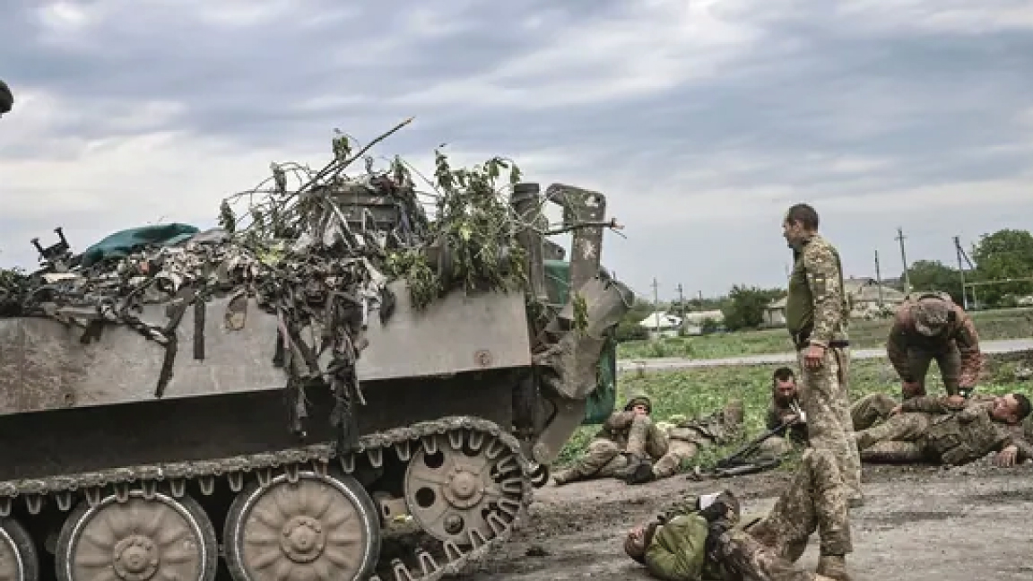 يساعد الجنود الأوكرانيون رفاقهم في مكان ليس بعيدًا عن خط المواجهة في منطقة دونباس بشرق أوكرانيا ، في 21 مايو 2022
