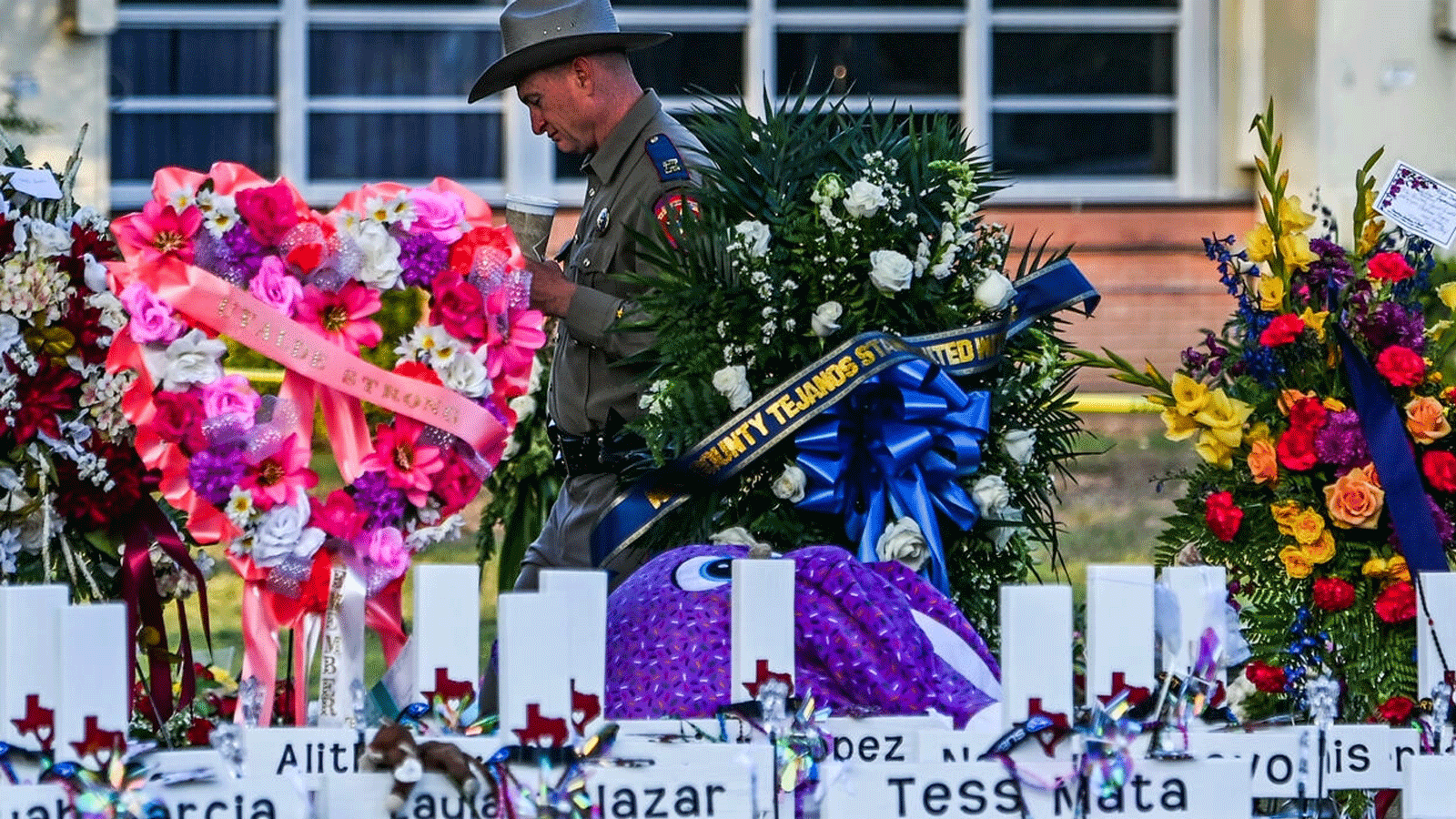ضابط شرطة يقف بالقرب من النصب التذكاري المؤقت لضحايا إطلاق النار خارج مدرسة روب الابتدائية في أوفالدي، تكساس. 28 ايار\مايو 2022