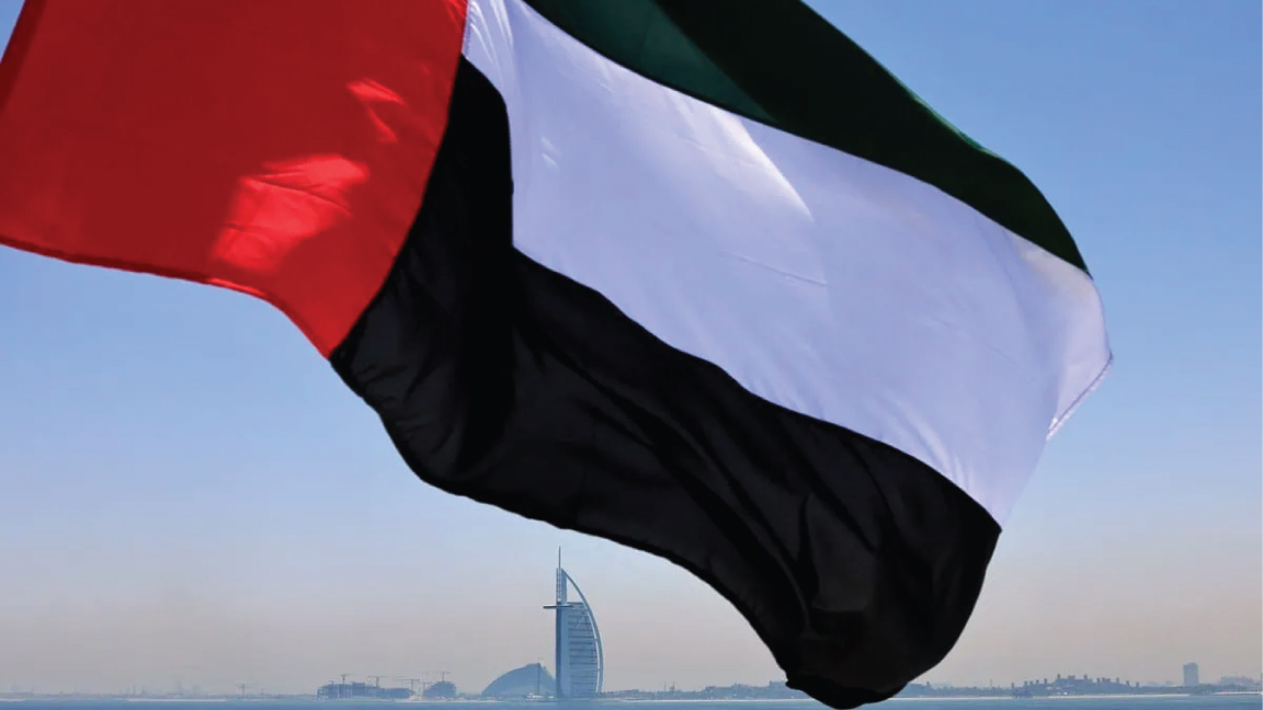 تُظهر هذه الصورة التي تم التقاطها في 3 يونيو 2021 علمًا إماراتيًا يرفرف فوق مرسى دبي مع فندق برج العرب في الخلفية