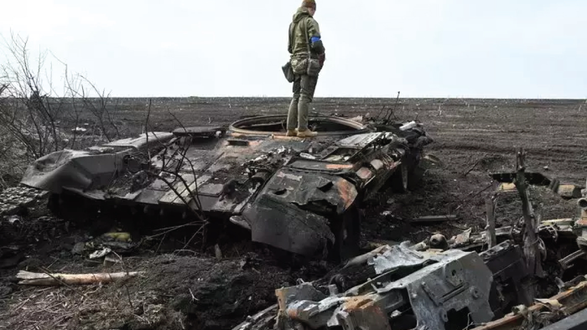 جندي أوكراني يقف على حطام دبابة روسية محترقة خارج قرية مالا روغان، شرق خاركيف، في 1 أبريل 2022
