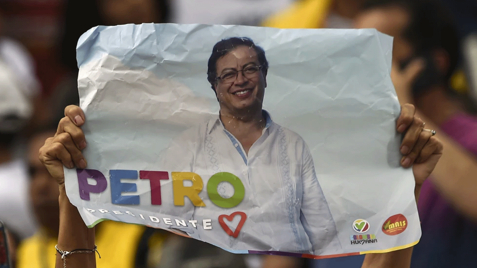 مناصر للمرشح الرئاسي الكولومبي غوستافو بيترو عن حزب كولومبيا هيومانا يحمل ملصقًا خلال تجمع انتخابي في كالي، كولومبيا 