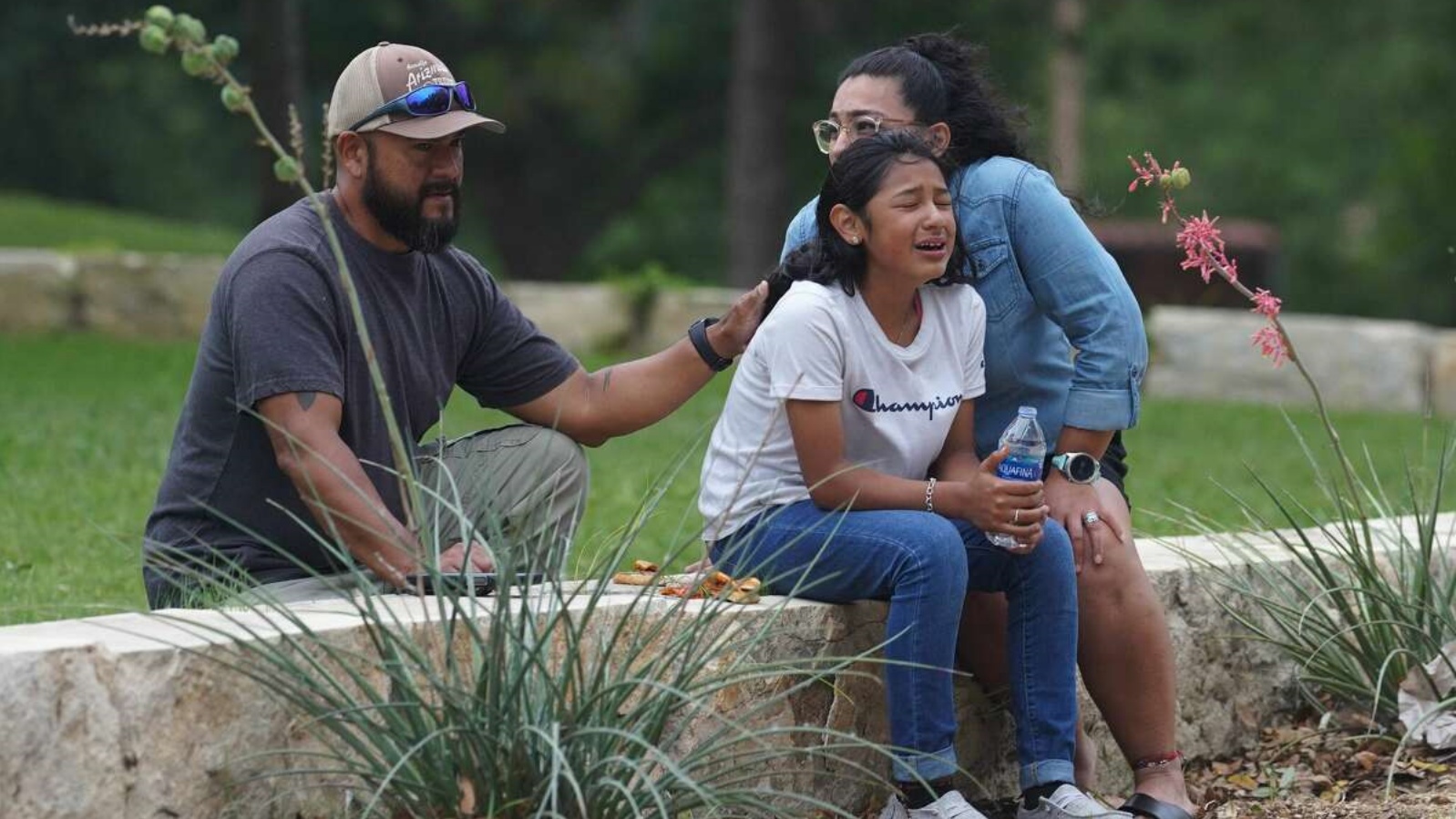عائلة تواسي طفلة تبكي أصدقاءها خارج مدرسة ابتدائية في تكساس 24 مايو 2022