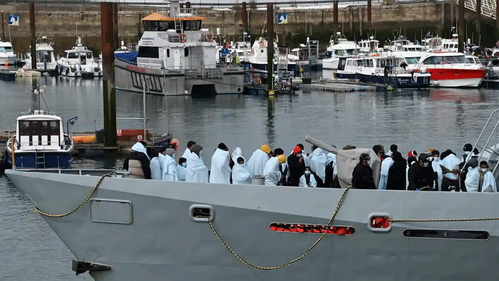 يتم إحضار المهاجرين إلى ميناء في مرسى دوفر من قبل قوة الحدود البريطانية بعد أن تم القبض عليهم وهم يعبرون القنال من فرنسا في 14 نيسان\ أبريل 2022