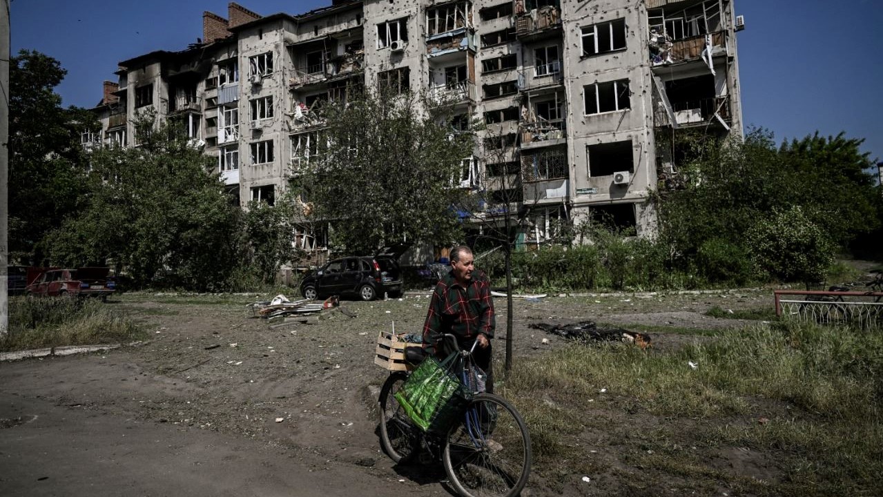رجل مسن يمر قرب مبنى سكني مدمر بعد هجوم في سلوفيانسك في منطقة دونباس شرق أوكرانيا ، في 31 مايو 2022