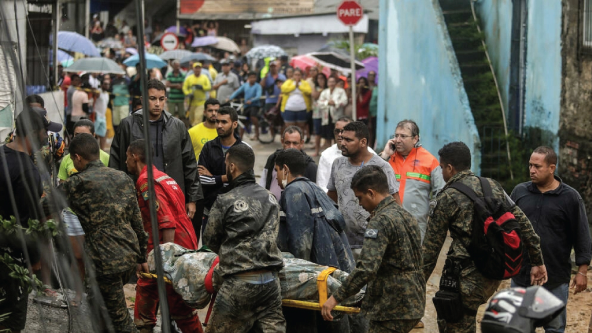 قام عمال الإنقاذ بنقل جثة ضحية من منطقة دمرها الانهيار الأرضي في جارديم مونتي فيردي في ريسيفي ، ولاية بيرنامبوكو ، البرازيل ، في 28 مايو 2022