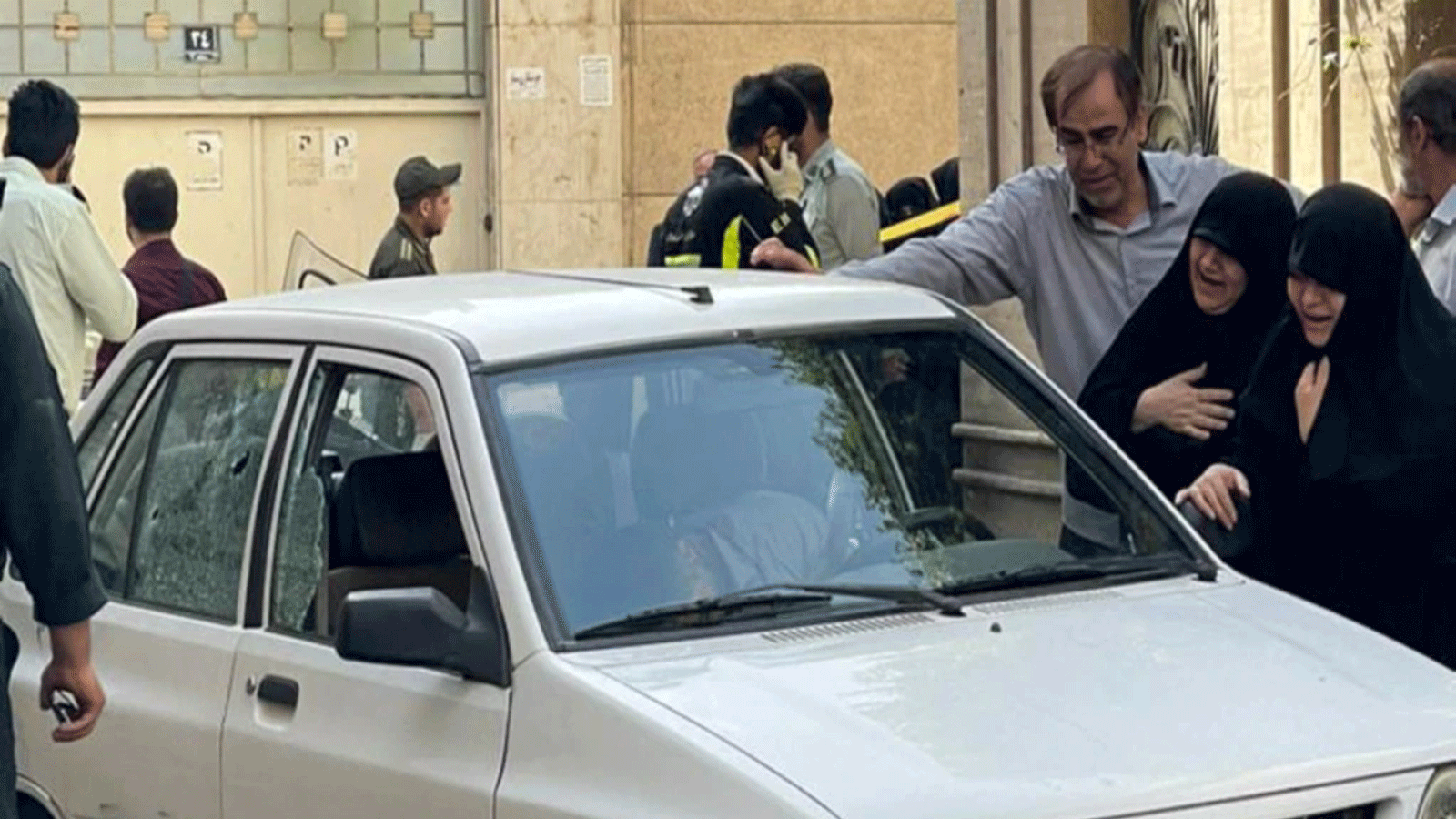 سيدتان تبكيان بجوار سيارة العقيد المغدور صياد خدائي حيث قُتل بالرصاص في طهران. في 22 أيار\مايو.2022