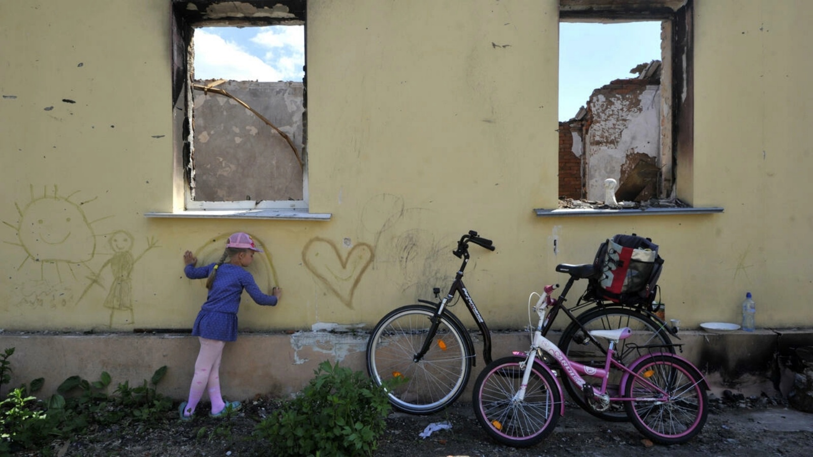 فتاة ترسم على جدار منزل مدمر في أندريفكا في منطقة العاصمة الأوكرانية كييف في 03 يونيو 2022 