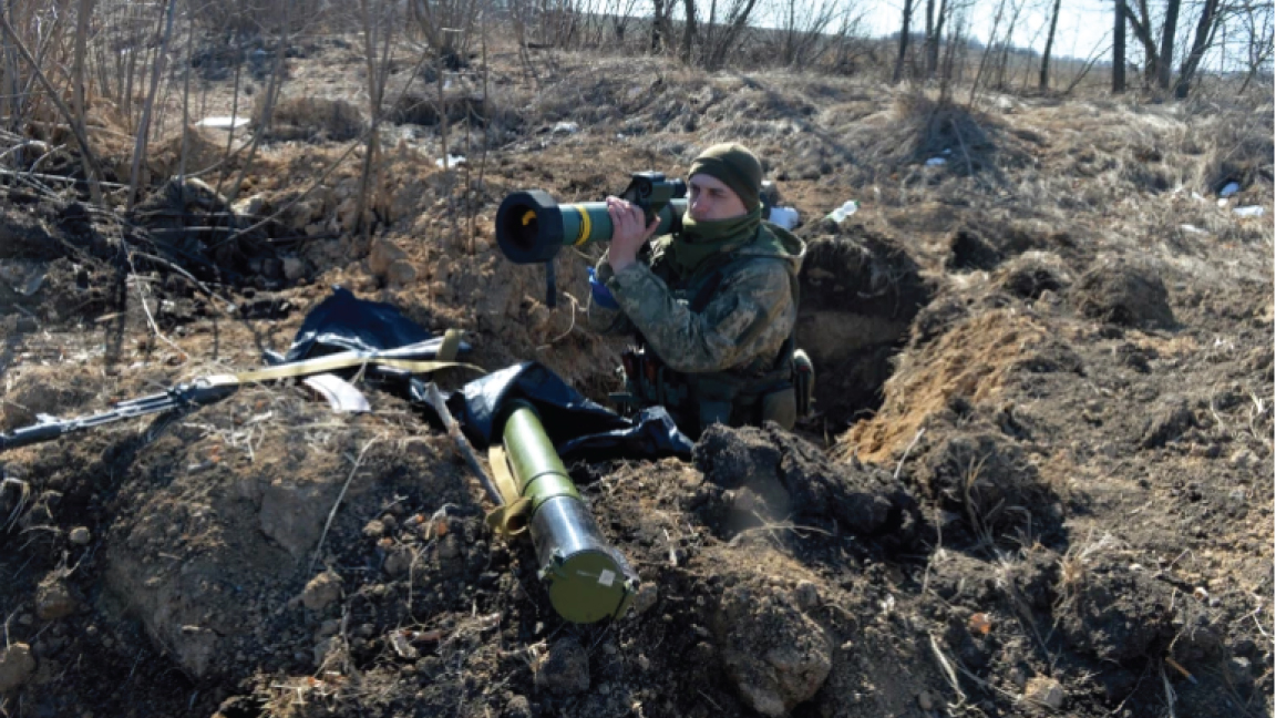 أحد أفراد القوات العسكرية الأوكرانية يحمل صاروخ جافلين المضاد للدبابات عند نقطة تفتيش قرب خاركيف