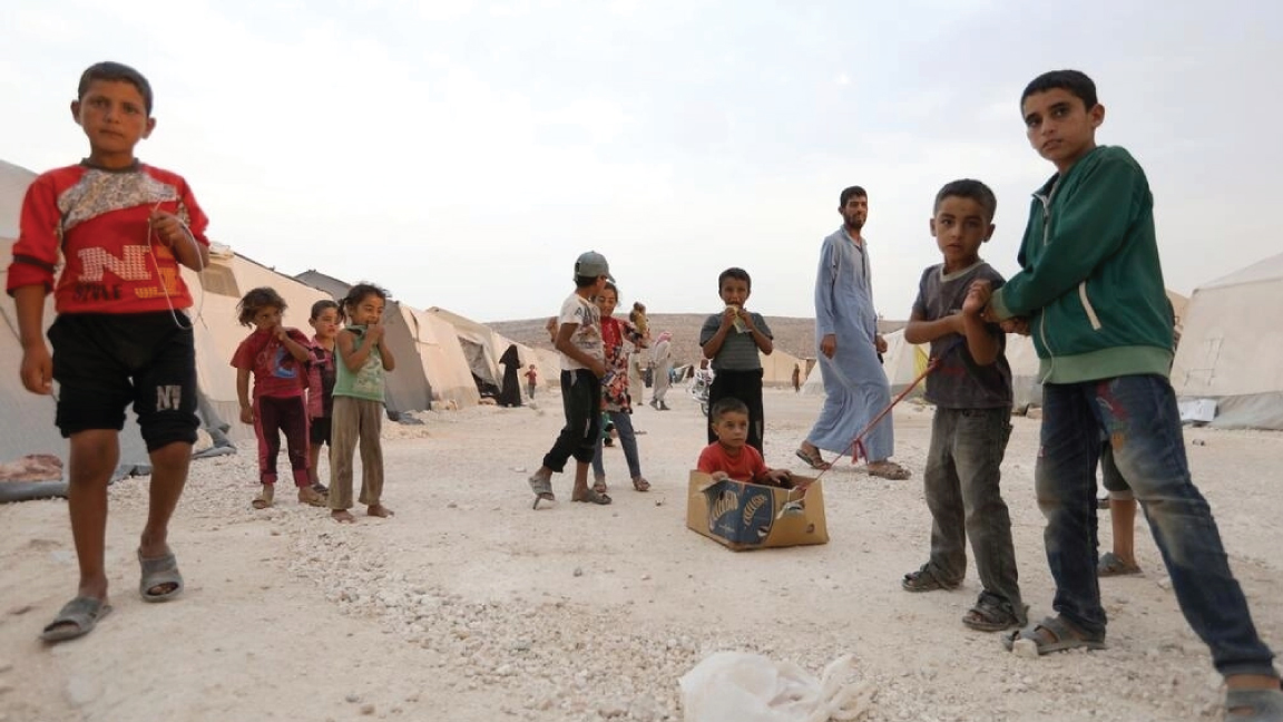 أطفال نازحون سوريون يلعبون في مخيم 