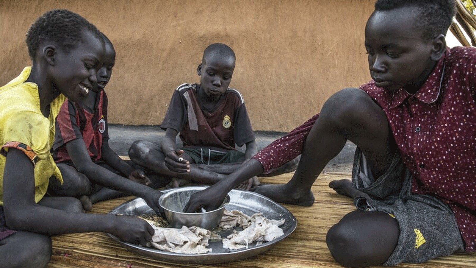 أطفال في قرية نيال بجنوب السودان يتشاركون الوجبة. الصورة: برنامج الأغذية العالمي