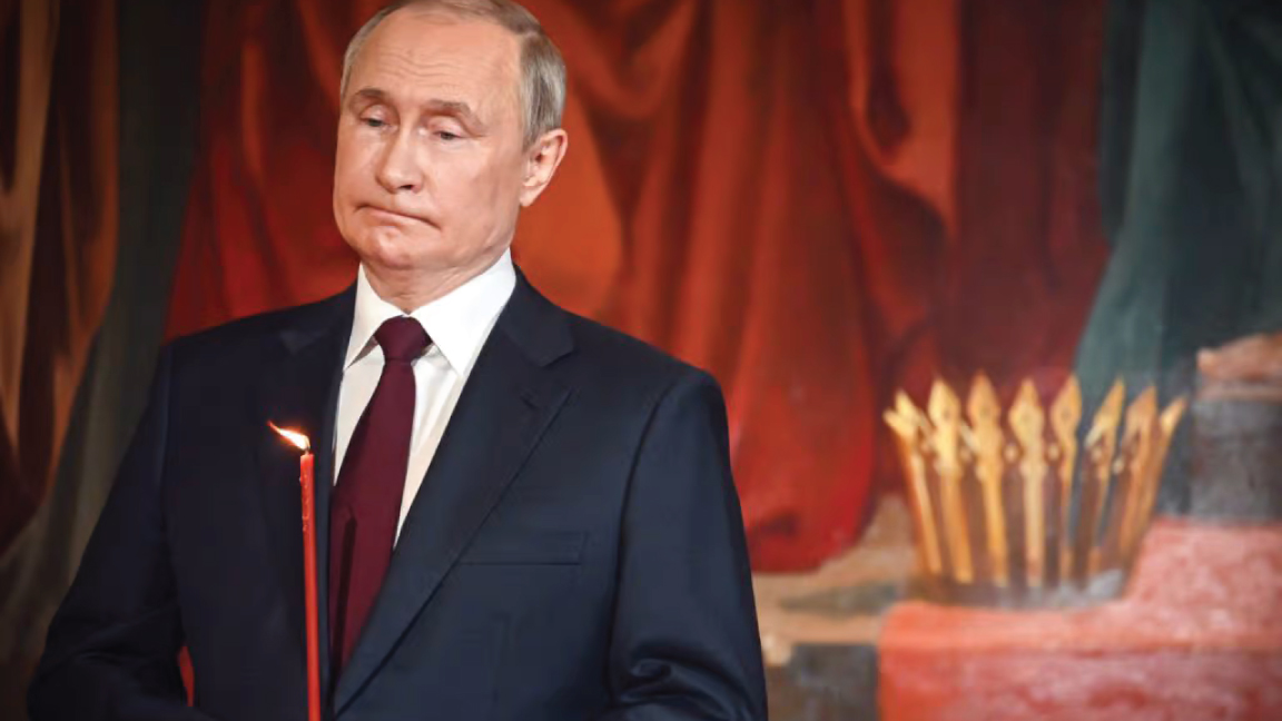 الرئيس الروسي فلاديمير بوتين يحمل شمعة خلال قداس عيد القيامة الأرثوذكسي في موسكو