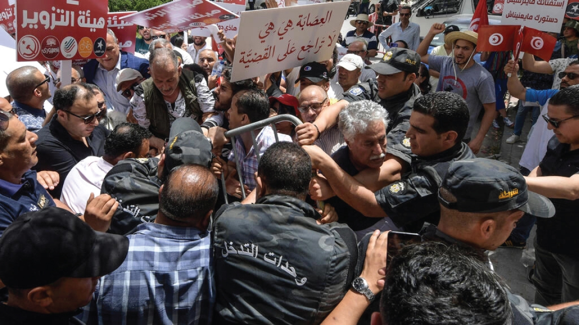 المتحدث باسم حزب العمال التونسي حمّة الهمامي بين متظاهرين منعتهم الشرطة من الاقتراب من مقر الهيئة العليا المستقلة للانتخابات في العاصمة تونس بتاريخ 4 يونيو 2022
