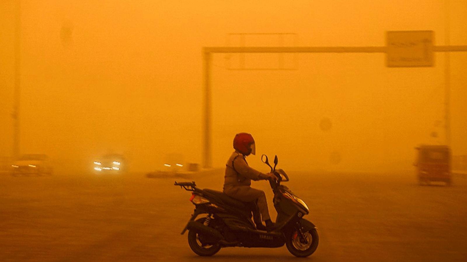 سائق يقود دراجة بخارية وسط عاصفة ترابية شديدة تضرب العاصمة العراقية بغداد. 16 أيار\مايو 2022
