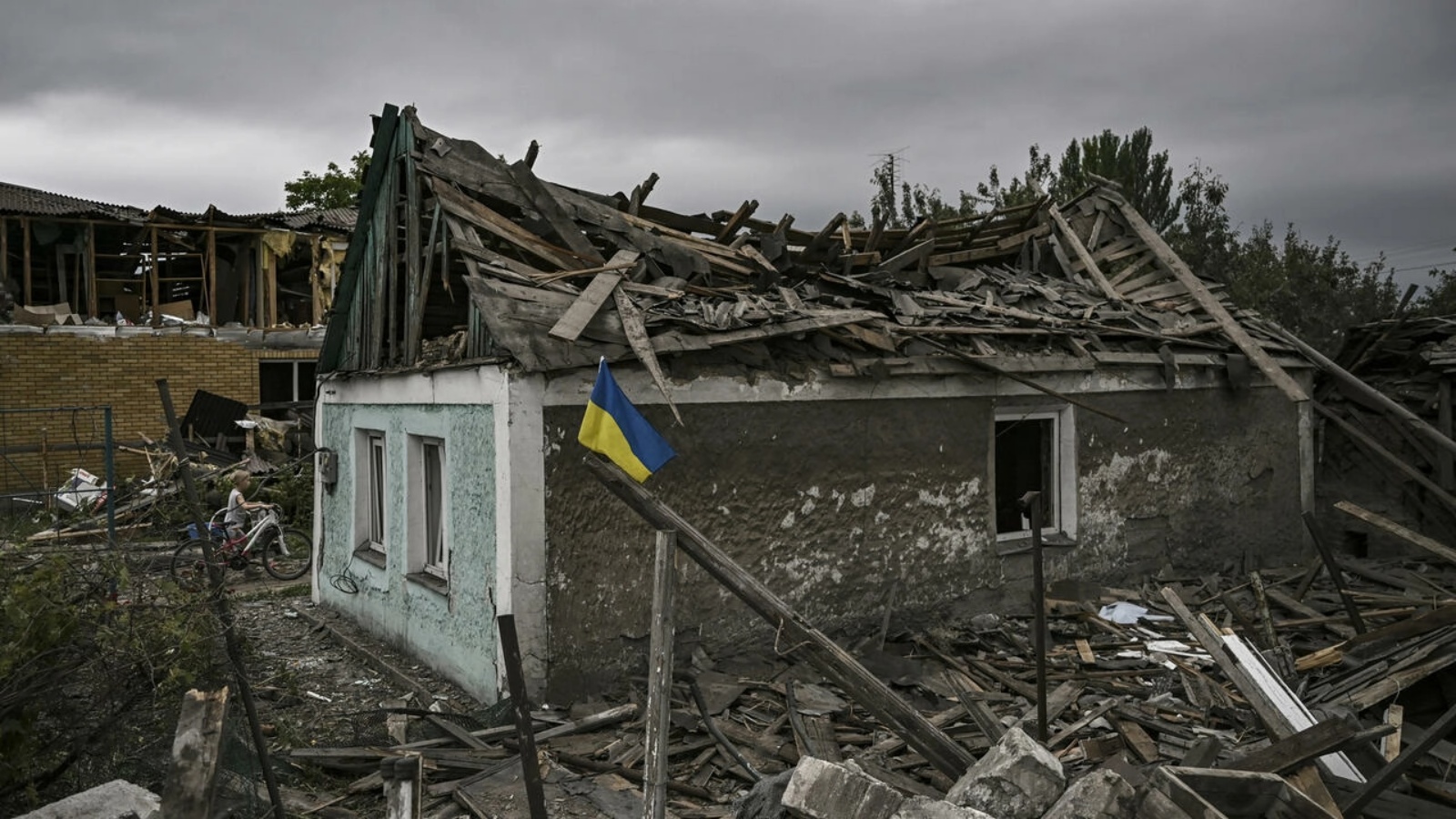 علم اوكراني أمام منزل مدمّر بضربة في دوبروبيليا في منطقة دونباس في شرق اوكرانيا في 15 يونيو 2022 