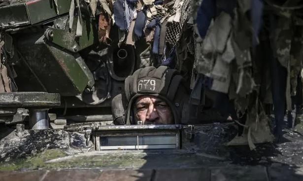 جندي أوكراني يقود دبابة باتجاه خط الجبهة في دونباس في 14 يونيو