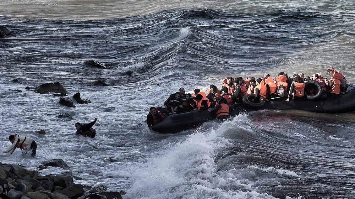 صورة من الأرشيف تظهر لاجئين ومهاجرين يحاولون الوصول إلى شاطئ ليسبوس وسط البحار الهائجة، بعد عبور بحر إيجه من تركيا