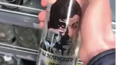 صورة للرئيس الأوكراني على زجاجة فودكا روسية وهو يمسح دمعةً في عينه اليمني