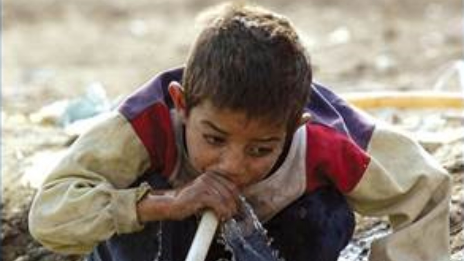 طفل عراقي يشرب من مياه ملوثة (توضيحية)