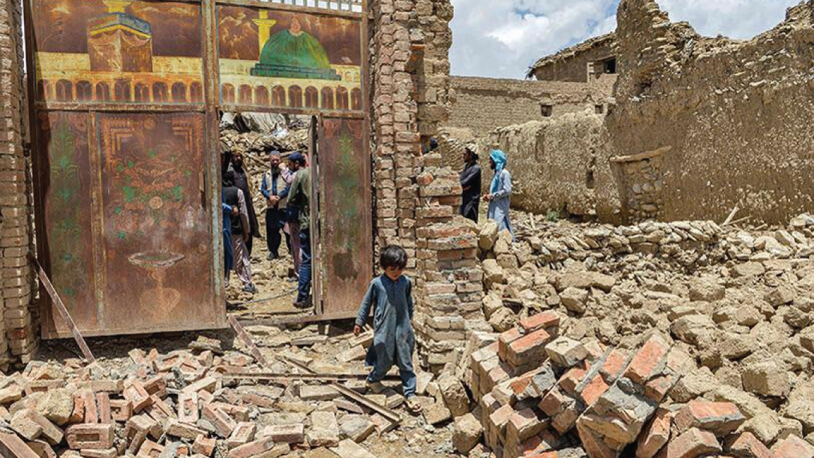 طفل افغاني يخرج من منزل دمره الزلزال في منطقة برنال، مقاطعة باكتيكا، في 23 يونيو 2022