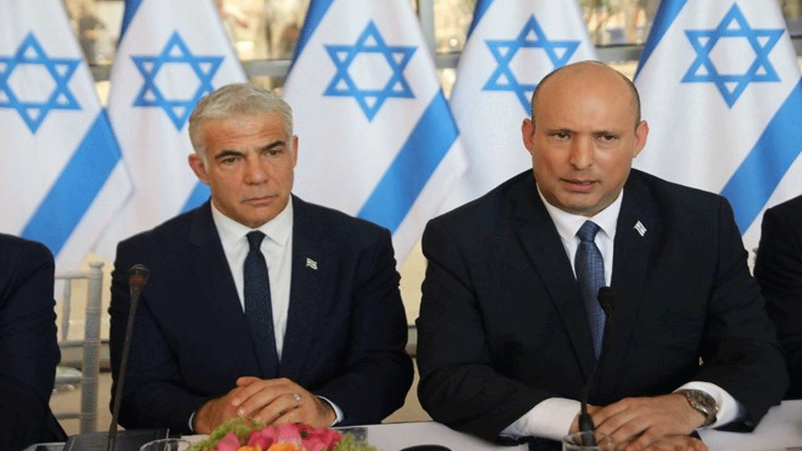 رئيس الوزراء الإسرائيلي نفتالي بينيت (يمين) ووزير الخارجية يائير لبيد، يحضران أحد الاجتماعات الأسبوعية لمجلس الوزراء في القدس