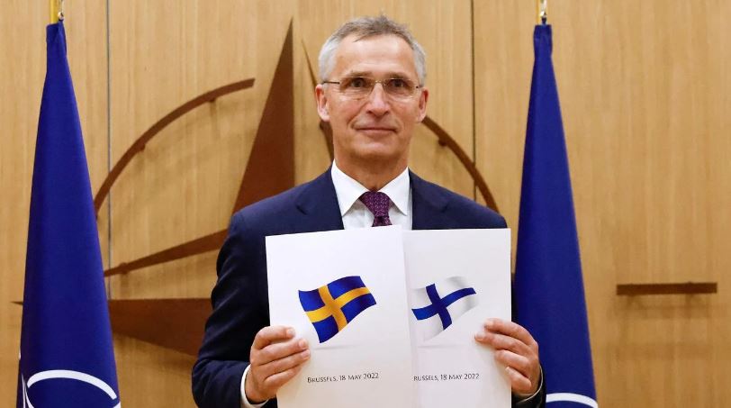 الأمين العام لحلف الناتو ينس ستولتنبرغ حاملًا وثائق مقدمة من السويد وفنلندا في بروكسل في 18 مايو 2022