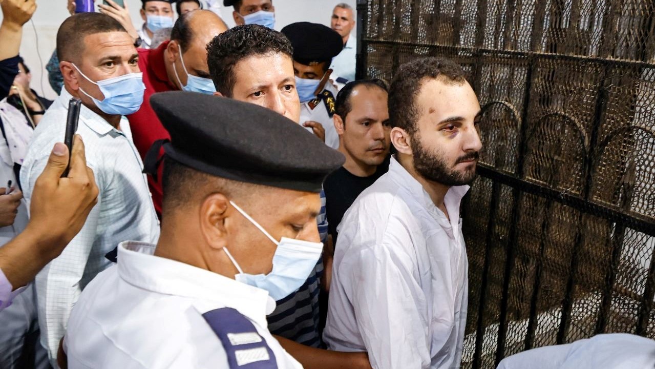 عادل (في الوسط) يحيط به الحراس في ختام أول جلسة محاكمة له في محكمة المنصورة شمال القاهرة، في 26 يونيو 2022