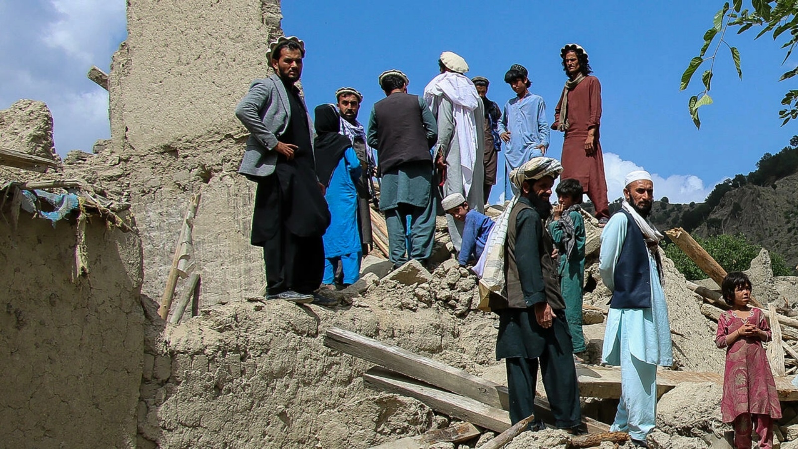 أفغان يقفون على أنقاض منزل دُمّر جراء الزلزال في منطقة غايان في شرق أفغانستان في 24 يونيو 2022 