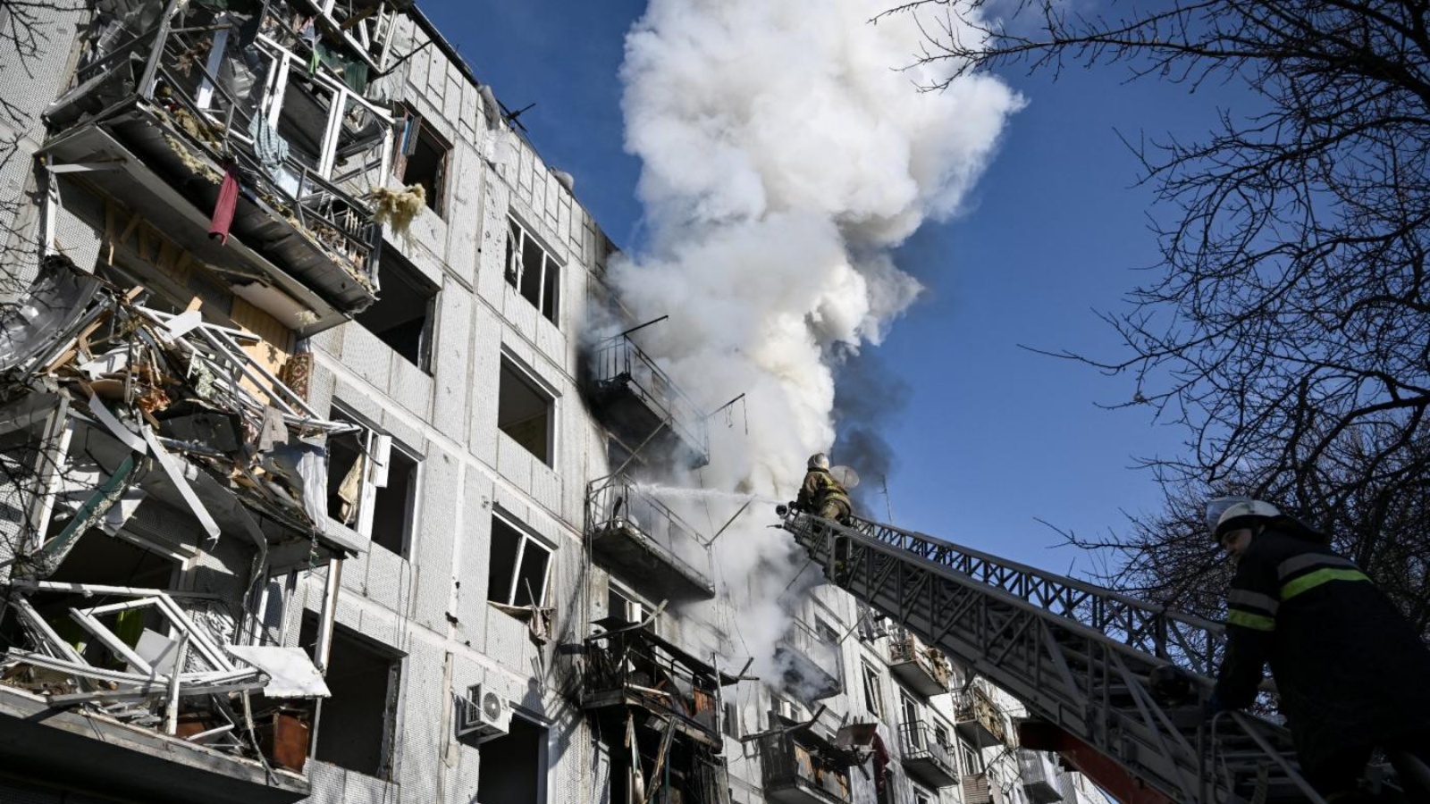 رجال الإطفاء يعملون على حريق في مبنى سكني بعد القصف الروسي