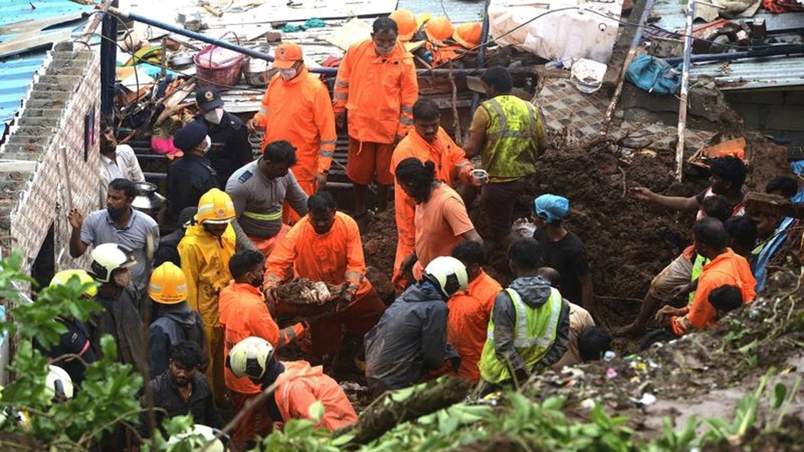 القوة الوطنية للاستجابة للكوارث (NDRF) وأفراد فريق الإنقاذ الآخرين يتفقدون موقع انهيار أرضي في منطقة فقيرة 