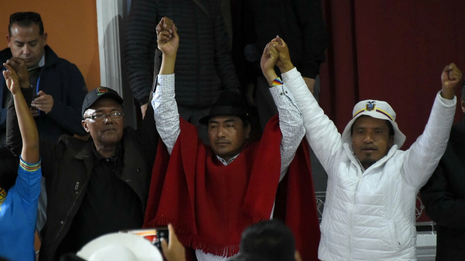 زعيم السكان الأصليين ليونيداس إيسا (وسط) ومسؤولون آخرون للسكان الأصليين يرفعون أياديهم بعد توقيع اتفاق مع الحكومة يضع حداً للتظاهرات احتجاجاً على غلاء المعيشة في 30 يونيو 2022