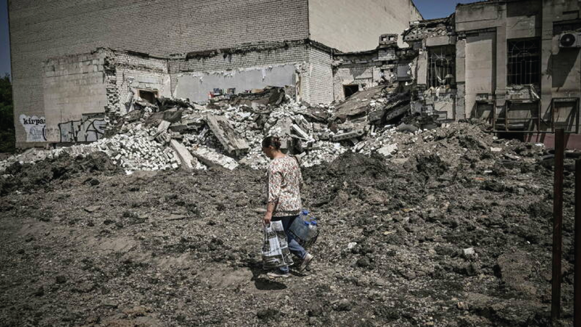 امرأة تمشي أمام مبنى مدمر في ليسيتشانسك في 30 مايو 2022
