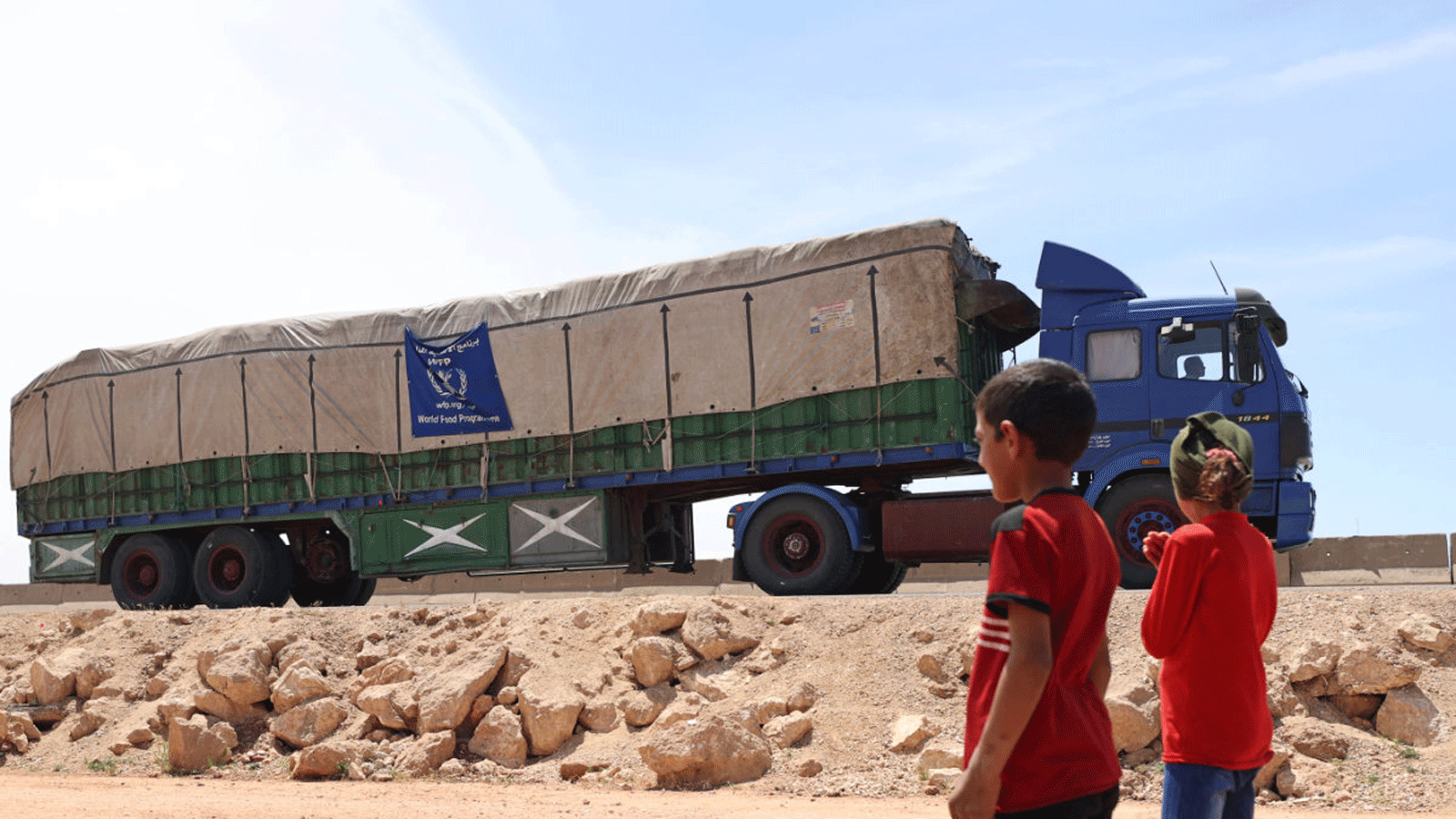 شاحنة تحمل طرود مساعدات من برنامج الغذاء العالمي تمرّ عبر بلدة حزانو في ريف إدلب الشمالي الذي يسيطر عليه الثوار، في 16 أيار\مايو 2022